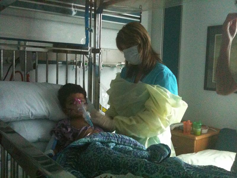 IMG_0229.JPG - The first two days he was in isolation and the staff had to gown up before entering the room. Here he is getting the nebulizer treatment for his breathing.