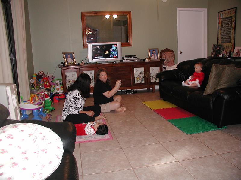 PC250063.JPG - On Christmas morning we went to James and Stephanie's place to open the gifts. Here is Stephanie trying to take a picture of Hannah but she has been distracted - Stephanie not Hannah.... distracted that is.