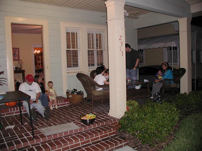 PA310011.JPG - Sitting on the porch after we went trick or treating. This house is in south Tampa and is owned by Jeff and Gerri. You see Jeff and Gerri sitting on the floor next to Hannah. Jeff is busy on his blackberry.